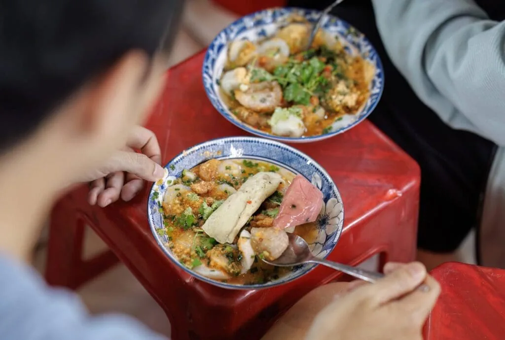Traditional Hue-style steamed rice cakes (Bánh Bèo) topped with dried shrimp and scallion oil, served at Ben Thanh Market.