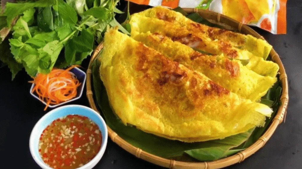 Crispy Vietnamese savory pancake (Bánh Xèo) filled with shrimp, pork, and bean sprouts, served at Ben Thanh Market in Ho Chi Minh City.