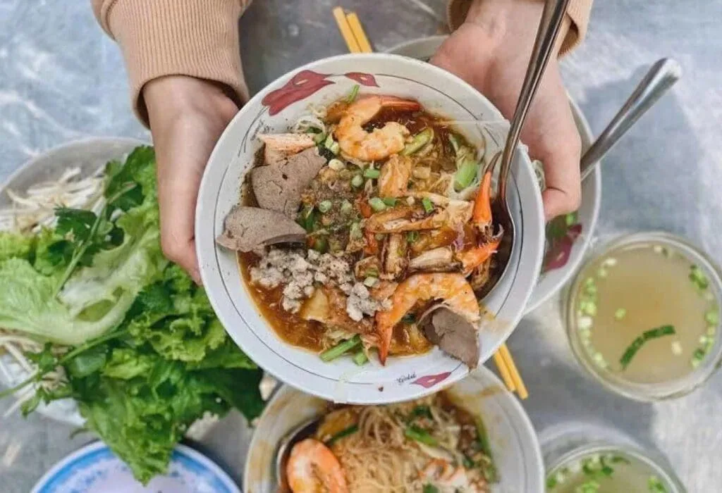 Vietnamese noodle soup (Hủ Tiếu) with pork, shrimp, and herbs served at Ben Thanh Market in Ho Chi Minh City.