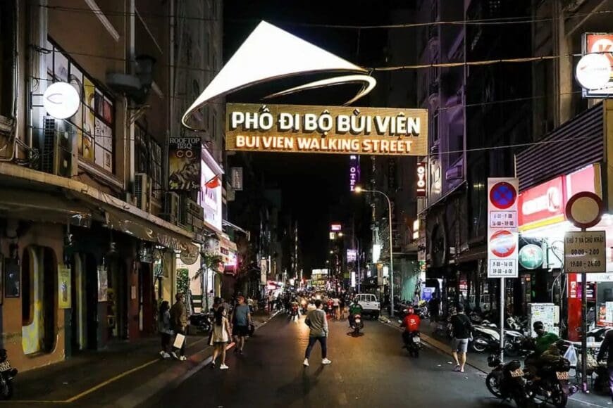 Vibrant night scene at Bui Vien Walking Street in Ho Chi Minh City, with colorful lights, street food stalls, and crowds enjoying Saigon nightlife.
