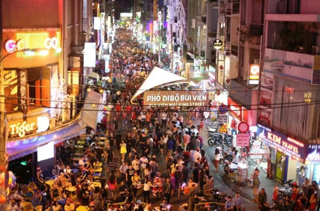 Crowds enjoying the vibrant nightlife at Bui Vien Walking Street in Ho Chi Minh City, filled with bars, restaurants, and colorful lights.