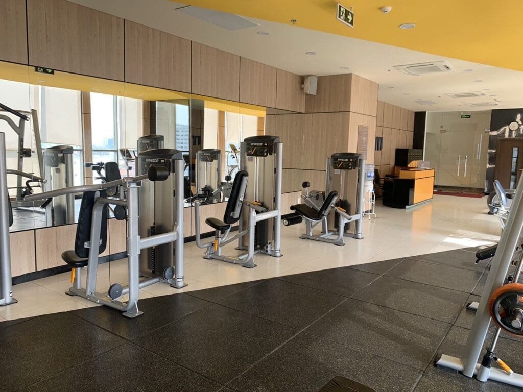 Modern gym with cardio machines and weight training equipment at RiverGate Residence Saigon