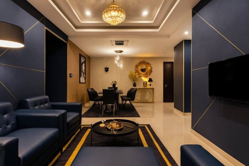 Phòng khách căn hộ 3 phòng ngủ tại RiverGate Residence, thiết kế sang trọng với sofa da, bàn ăn và đèn chùm hiện đại – lựa chọn hoàn hảo cho gia đình Việt kiều 4–6 người khi về nước nghỉ dưỡng dài ngày.